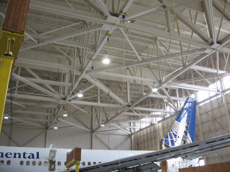 Overhead rigid rail in an aircraft maintenance hangar with the tail of an airliner below