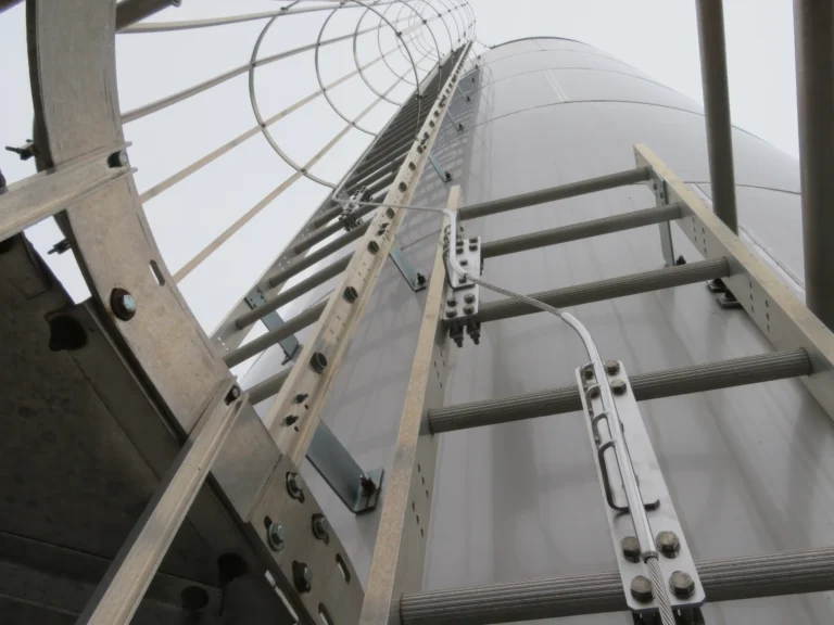 Close-up of a vertical rail lifeline mounted on a fixed ladder up the side of a silo