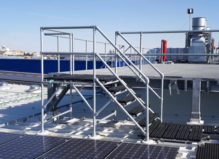 Aluminum crossover stairs and platform with handrails over rooftop solar panels